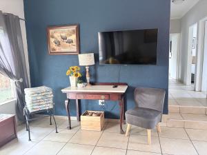 a room with a desk and a tv on a blue wall at Dew Drop Inn in Nelspruit