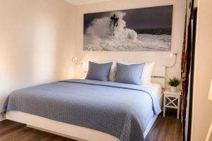 a bedroom with a bed and a painting on the wall at Zugvogel EG in Wangerland