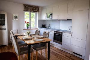 a kitchen with a wooden table with chairs and a dining room at Zugvogel EG in Wangerland