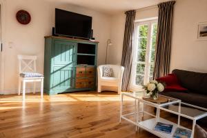 a living room with a green cabinet with a flat screen tv at Zugvogel EG in Wangerland