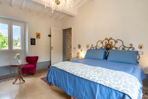 a bedroom with a blue bed and a red chair at casa stella a due passi dal centro in Arezzo