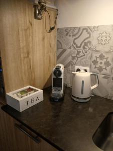 a kitchen counter with a coffee maker and a tea kettle at Mas Tulipe de Soie in Bevons