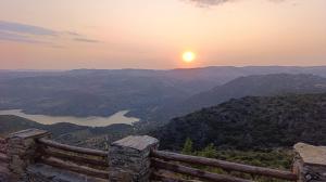 a sunset over a mountain range with a fence at El hogar de Gregorio in Vilvestre