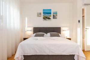 a bedroom with a large white bed with white sheets at Penthouse Petar in Kastel Stari +52 photos