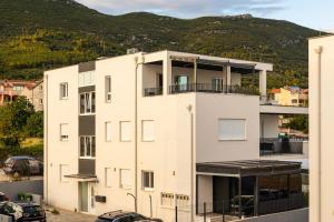 a white building with a mountain in the background at Penthouse Petar in Kastel Stari