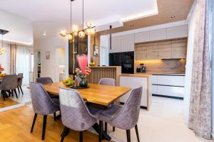 a kitchen and dining room with a wooden table and chairs at Penthouse Petar in Kastel Stari
