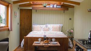 a bedroom with a bed and a table with a bowl of fruit at Bertha Shepherd's Hut in Lydney