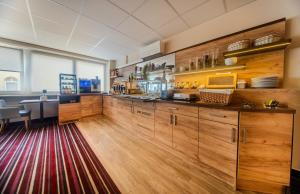 eine Küche mit Holzschränken und einem roten Teppich in der Unterkunft Hotel Süderelbe in Hamburg