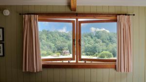 a window with a view of a forest at Bertha Shepherd's Hut in Lydney