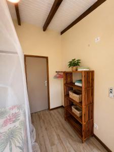 a room with a bed and a shelf with towels at Gîte Avocatier - Villa Marina in Bouillante +3 photos