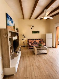 a living room with a couch and a ceiling fan at Gîte Avocatier - Villa Marina in Bouillante
