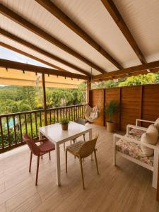 a patio with a table and chairs on a deck at Gîte Avocatier - Villa Marina in Bouillante