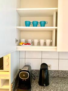 a kitchen with a toaster and bowls on shelves at Belga Apartment 3 bedrooms. in Antwerp +5 photos