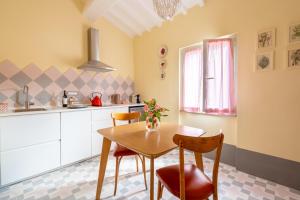 a kitchen with a wooden table and two chairs at casa stella a due passi dal centro in Arezzo