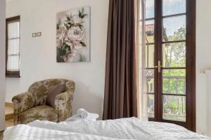 a bedroom with a bed and a chair and a window at Katy Lake Timo in Sirmione