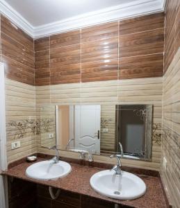a bathroom with two sinks and a large mirror at Sami apartment in Alexandria
