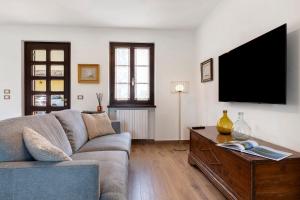 a living room with a couch and a tv at Katy Lake Timo in Sirmione