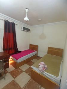 a small room with two beds and a desk at Sami apartment in Alexandria