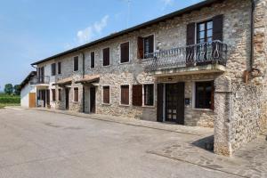 a stone building with a balcony on the side of it at Katy Lake Timo in Sirmione