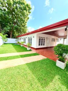 a house with a red roof and a green yard at Villa 87 - Anuradhapura in Anuradhapura