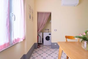 a laundry room with a washing machine and a dining room table at casa stella a due passi dal centro in Arezzo