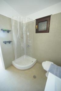 a white bathroom with a shower and a toilet at River side house in Kastoria +44 photos