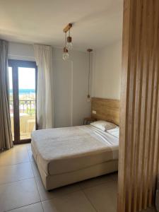 a bedroom with a bed and a large window at Minoa Apartments in Amoudara Herakliou +36 photos