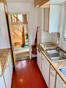 a kitchen with a sink and a staircase at Chalet Panorama in Adelboden
