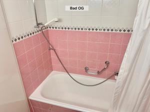 a pink tiled bathroom with a tub and a shower at Chalet Panorama in Adelboden +21 photos