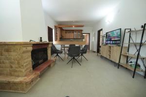 a living room with a fireplace and a table and chairs at River side house in Kastoria