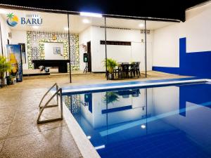 a swimming pool in a room with a piano at Hotel Barú Melgar in Melgar