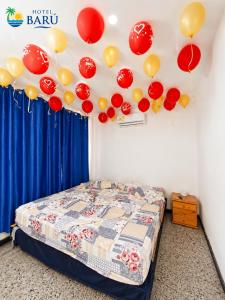 a room with a bed with balloons on the ceiling at Hotel Barú Melgar in Melgar +25 photos