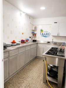 a kitchen with a sink and a counter in it at Hotel Barú Melgar in Melgar