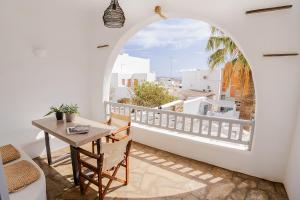 a room with a table and a balcony with a view at Onar Hotel & Suites in Tinos