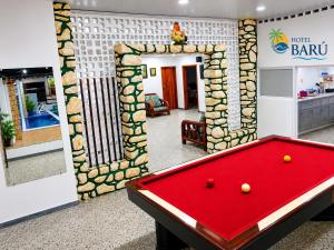a red pool table in a room with at Hotel Barú Melgar in Melgar