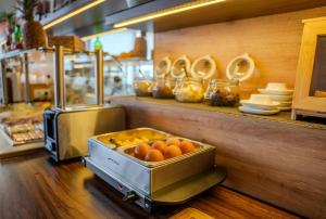 eine Küche mit einer Theke, auf der eine Kiste Orangen steht in der Unterkunft Hotel Süderelbe in Hamburg + 38 Fotos