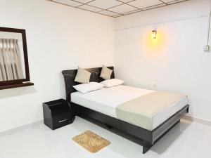 a bedroom with a bed in a white room at Villa 87 - Anuradhapura in Anuradhapura
