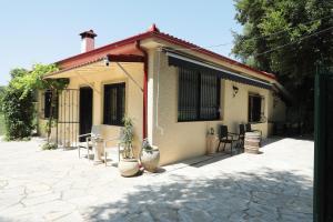 a house with a patio with chairs and a table at River side house in Kastoria