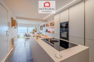 a kitchen with white cabinets and a large counter top at La Braveta in Sant Antoni de Calonge