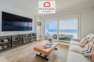 a living room with a large tv and a table at La Braveta in Sant Antoni de Calonge