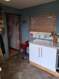 a kitchen with a counter and a red stool at The Old Waterworks - Venus Bell Tent in Clare +8 photos