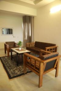 a living room with a couch and a table at Rivayn Suites in Thiruvalla