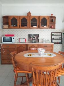 a kitchen with a wooden table and wooden cabinets at Casa da Maria in Amoreira