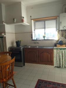 a kitchen with a sink and a stove at Casa da Maria in Amoreira +3 photos