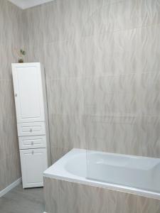 a bathroom with a white bath tub next to a dresser at Casa da Maria in Amoreira