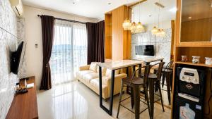 a kitchen and living room with a couch and a table at Pentapolis Apartment Balikpapan Superblock LT4 in Balikpapan