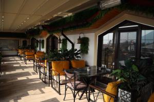 a restaurant with tables and chairs and plants at Mountain-city in Zaqatala