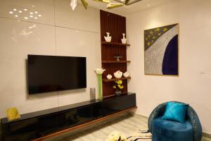 a living room with a television and a blue chair at Apartment60 in Lagos +17 photos
