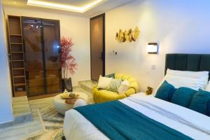 a bedroom with a large bed and a yellow chair at Apartment60 in Lagos