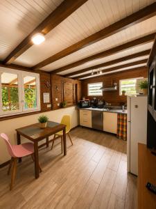a kitchen with a wooden table and a table and chairs at Gîte Bananier - Villa Marina in Bouillante
